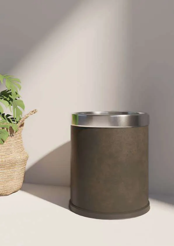 Corbeille de chambre en similicuir marron à bord chromé, près d’un panier en osier